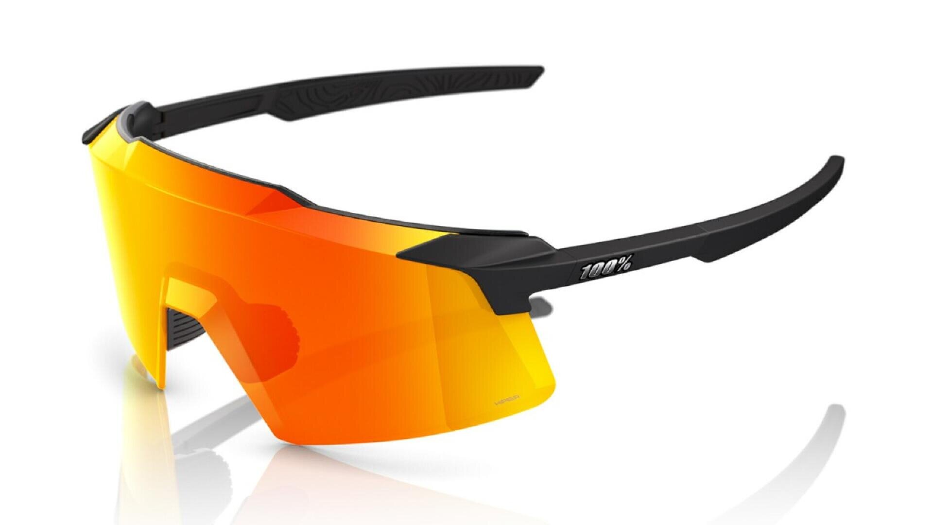 A pair of sporty sunglasses with a single large orange-tinted lens and black arms, featuring the 100% logo on the side. The design is sleek and modern, suitable for cycling or outdoor activities.
