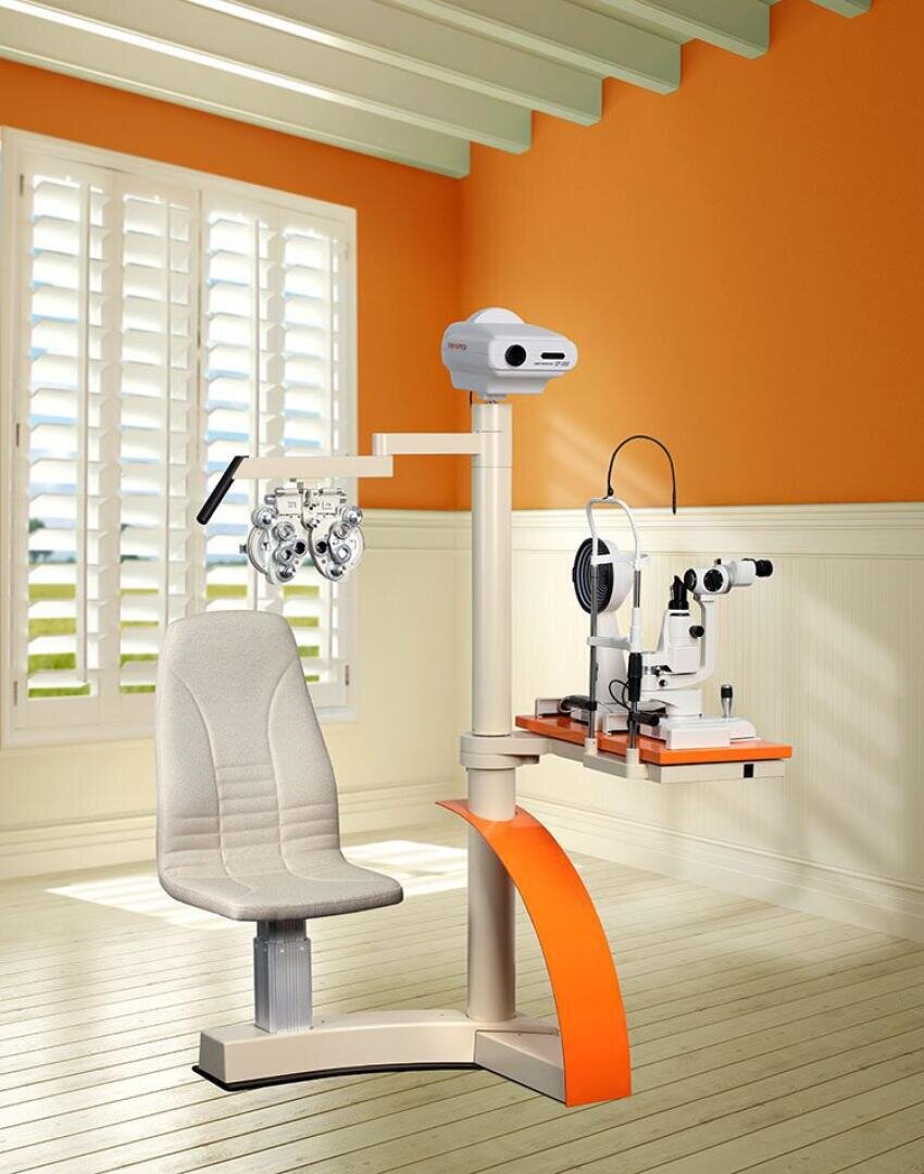 Ein moderner Augenuntersuchungsraum mit orangefarbenen und weißen Wänden verfügt über einen Augenuntersuchungsstuhl, einen Phoropter und eine Spaltlampe und ist neben einem Fenster mit weißen Fensterläden platziert, durch das Sonnenlicht hereinströmt.