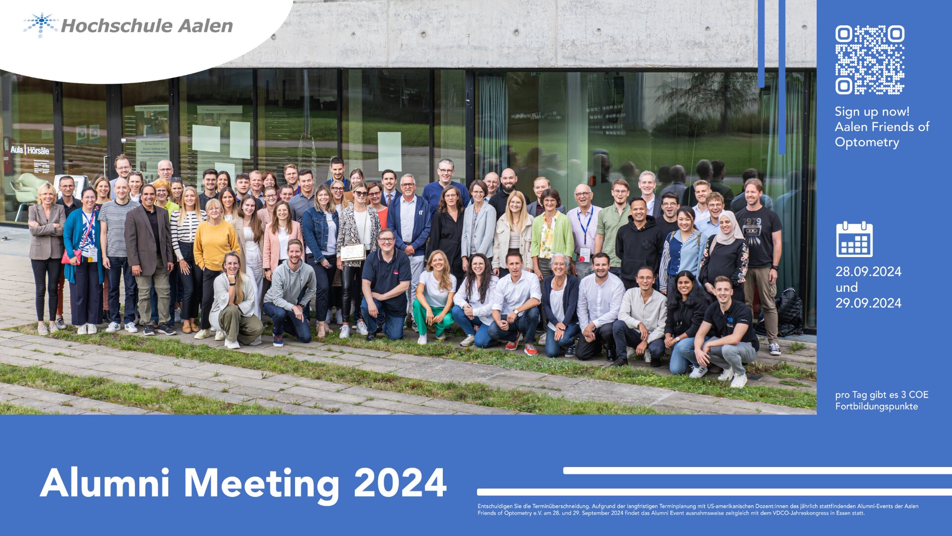 Eine große Gruppe von Menschen posiert für ein Foto vor einem modernen Glasgebäude. Ein blaues Banner wirbt für das "Alumni-Treffen 2024" an der Hochschule Aalen mit Veranstaltungsterminen, einem QR-Code und dem Aufruf, sich für den Freundeskreis Optometrie zu registrieren.