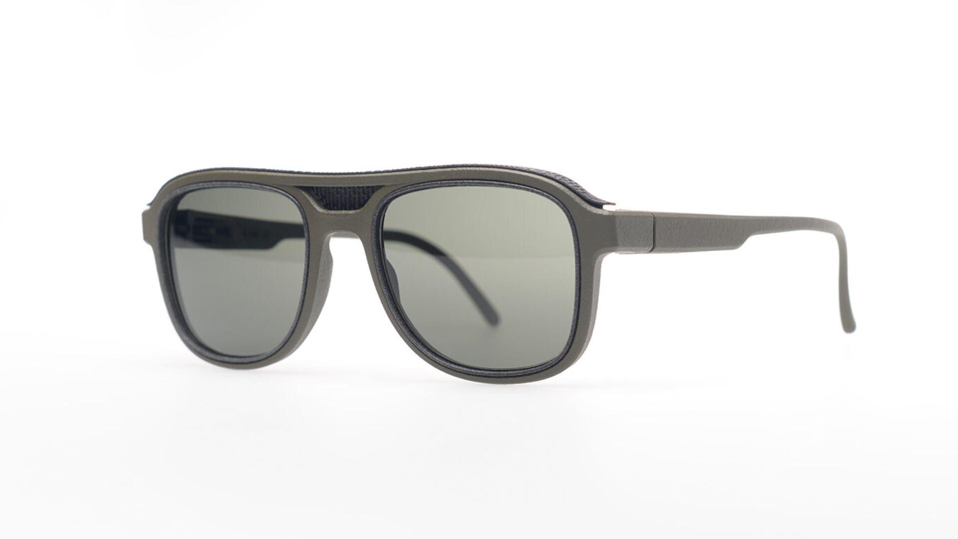 Eine schwarze Sonnenbrille im Pilotenstil mit dunkel getönten Gläsern und mattem Finish, abgebildet vor einem schlichten weißen Hintergrund.