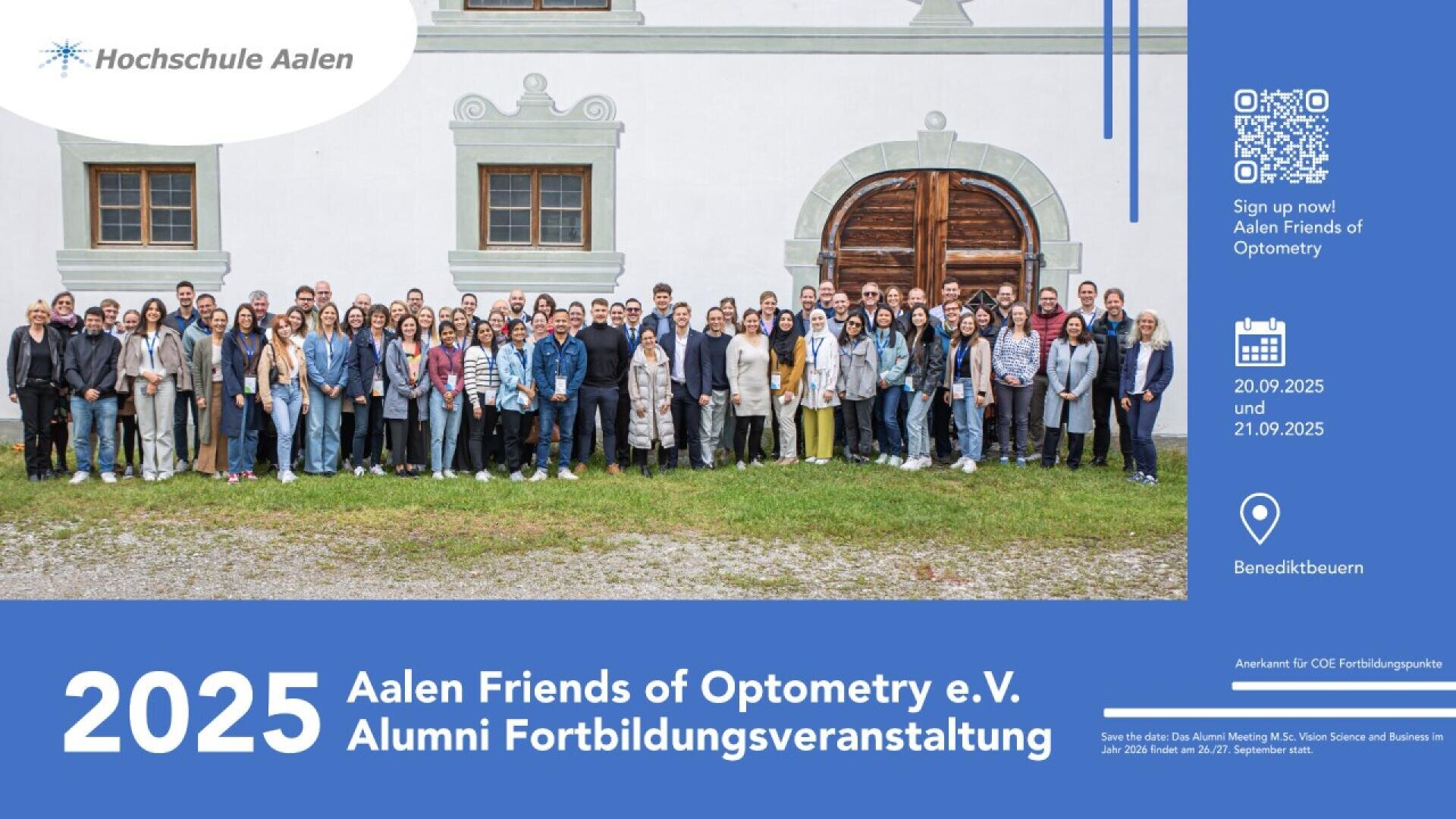Eine große Gruppe von Menschen steht vor einem historischen Gebäude mit Holztüren und posiert für ein Gruppenfoto. Die Veranstaltungsdetails zum Alumni-Treffen der Aalener Freunde der Optometrie 2025 werden unten auf einem blauen Banner angezeigt.