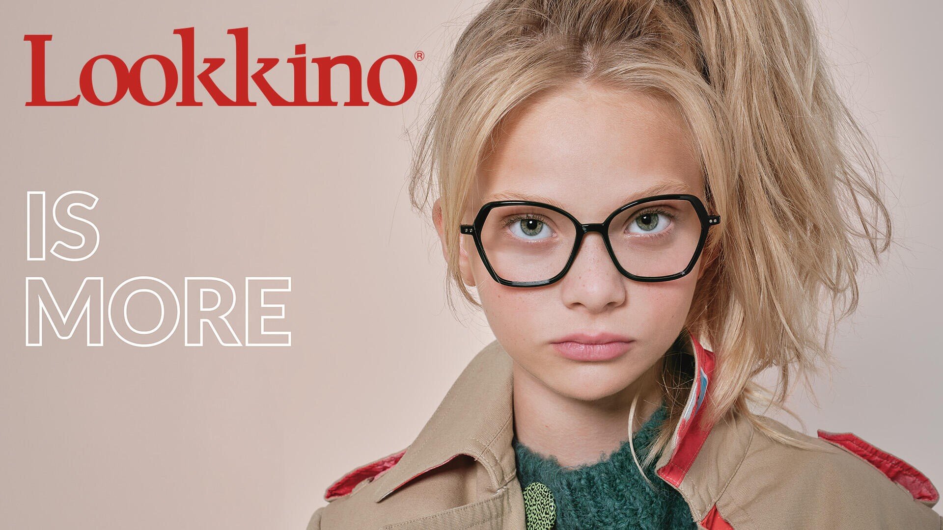 A young person with long blonde hair in a high ponytail wears large, black-rimmed glasses and a tan coat. The text reads “Lookkino IS MORE” on a light background.