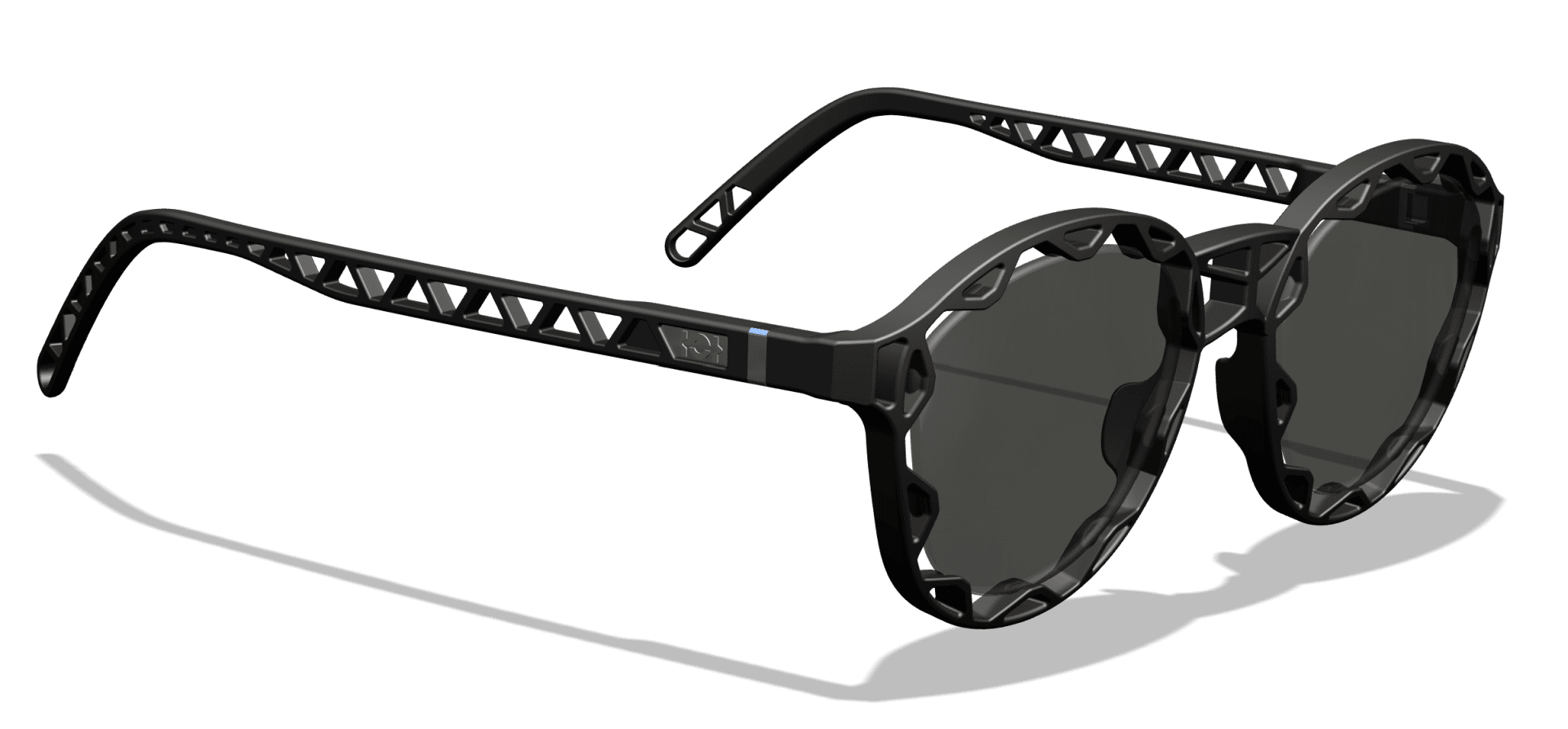 Black sunglasses with round, dark lenses and unique geometric cut-outs along the temples and frame that cast a shadow on a white surface.