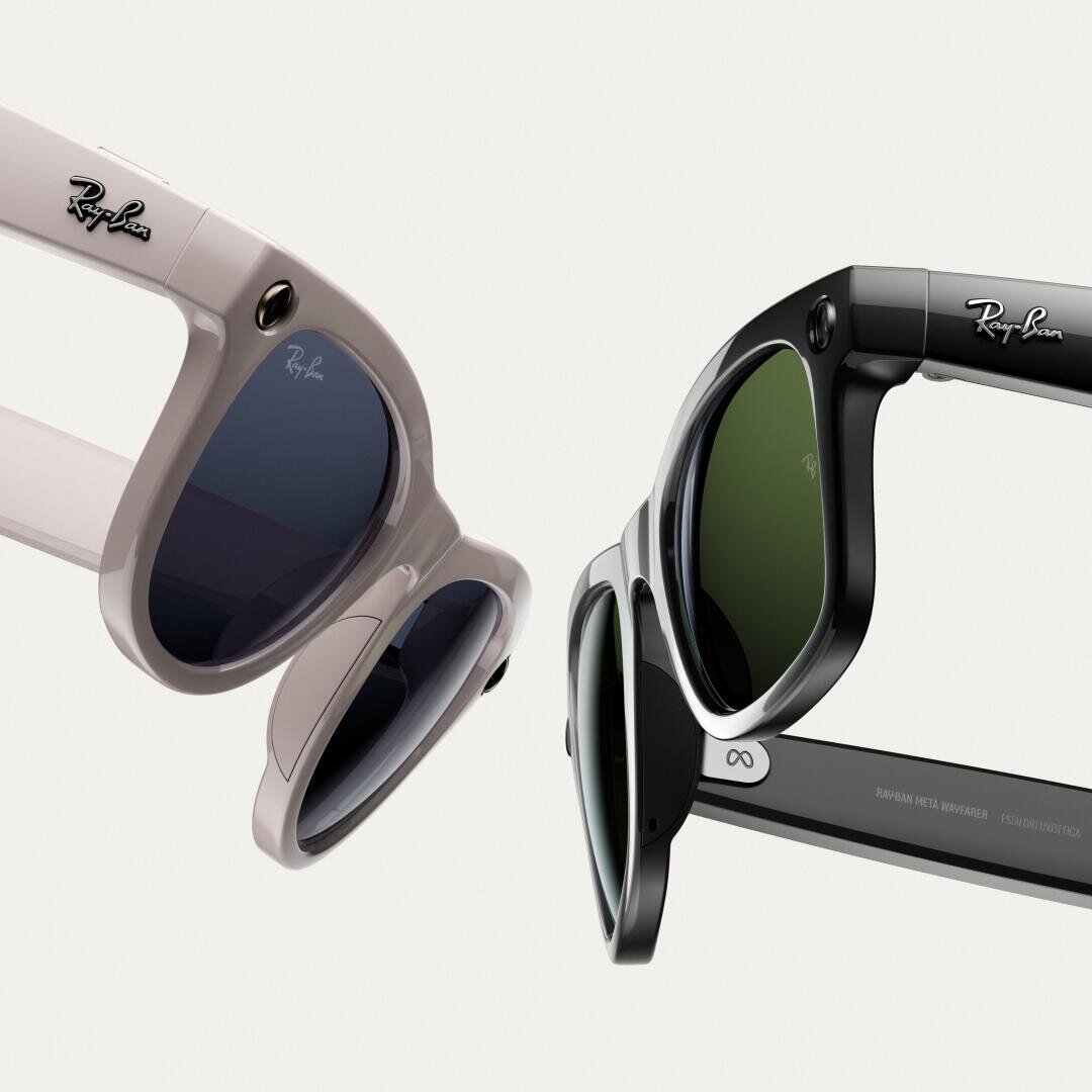 Zwei Ray-Ban-Sonnenbrillen, eine hellrosa und eine schwarze, werden in Nahaufnahme gezeigt, wobei die Rahmen, Gläser und Logos vor einem schlichten weißen Hintergrund hervorgehoben werden.